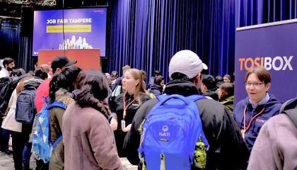 Valokuva Job Fair Tampere -tapahtumasta, jossa työnantajayritykset keskustelevat potentiaalisten työnhakijoiden kanssa.