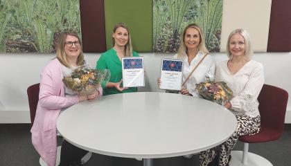 Vuoden lukuteko -palkittuja istumassa pöydän ääressä. 