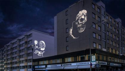 Kuva iltahämärästä kaupungilla, ja rakennuksien seinille on heijastettu piirustuksia.