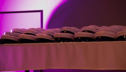 pöytä, jonka päällä on ylioppilaslakkeja.