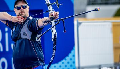 Jousiampuja tähtäämässä jousipyssyllä maaliin 