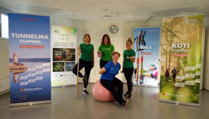 Hymyileviä liikunnanohjaajia jumppavälimeiden kanssa. 