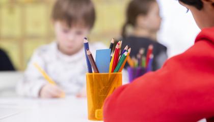 Lapsia piirtämässä. Yksi lapsi etualalla.