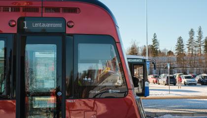 Punaisen ratikan ja sinisen bussin keulat.