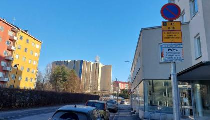 Autoja parkissa Kalevassa. Etualalla liikennemerkki, jossa siirtokehotustaulu.