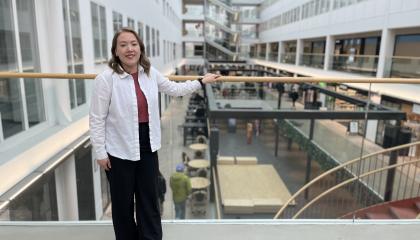 Henkilö katsoo kohti kameraa ja nojaa kaiteeseen Tullintorin kauppakeskuksessa.