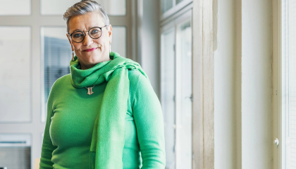 Henkilö seisoo ikkunan edessä ja katsoo kameraan.