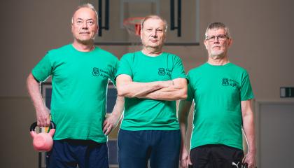 Kolme henkilöä seisoo rivissä. Kahdella on käsissään kahvakuulat.