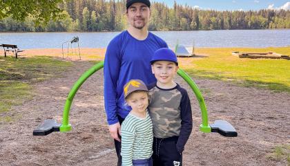 Isä ja kaksi lasta Peltolammin uimarannalla.