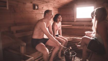 Ihmisiä istumassa saunan lauteilla.