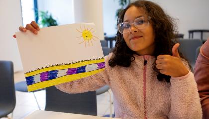 Nuori näyttää piirustustaan kameralle.