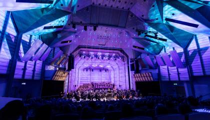 Tampere Filharmonia konsertoimassa Tampere-talon Isossa salissa. Salissa sinisävyinen valaistus.