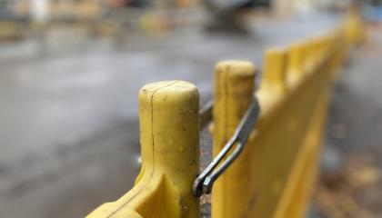 Keltaista katutyömaa-aitaa työmaan reunalla.