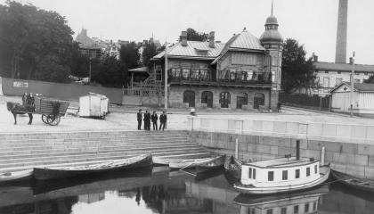  Mustavalkoisessa valokuvassa Laukontori 1908. Taustalla Kauppaseuran talo. Etualalla venevalkama, joka oli käytössä vain kymmenen vuotta ja täytettiin 1910.  