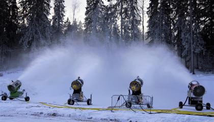 Lumitykkejä tekemässä lunta