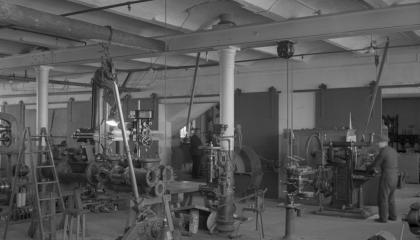 Paja, jossa on koneita ja ihmiset työskentelevät niiden ympärillä.