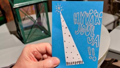 käsi pitelemässä joulukorttia