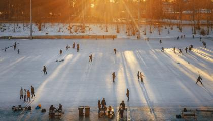 Sorsapuiston ulkojäällä ihmisiä ja laskevan auringon valo. 