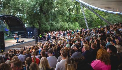 Kesäteatterilavalla festivaaliesitys sekä yleisöä.