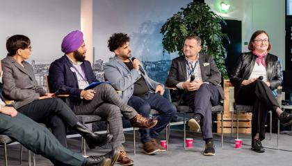 Growth with international talent -forum. Five panelists speak on stage at the forum.