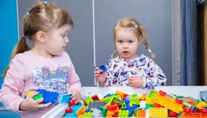 Kaksi lasta käsittelee lego-palikoita.