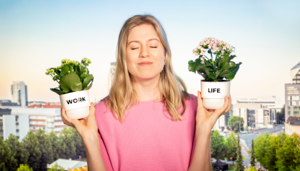 Henkilö on silmät kiinni ja pitelee molemmissa käsissään kukkaruukkuja tasapainossa. Toisessa kukkaruukussa lukee work ja toisessa life. Takana Tampereen kaupunkimaisema.