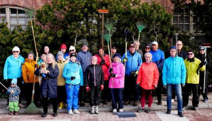 Siisteystalkoisiin osallistuneita henkilöitä seisoo kahdessa rivissä ja katsoo kameraan.