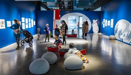 Taidenäyttelyn vieraat tutustuvat muumiteoksiin. 