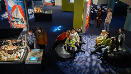 Ihmiset viettävät aikaa Muumimuseossa teoksia tutkien.