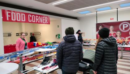 Pariskunta lastenvaunuineen katselee suksia SporttiSwap-tapahtumassa.