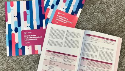 Kolme kirjaa matolla, joista yksi on keskiaukeamalta auki.