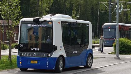 Robottibussi Hervantajärven pysäkillä. Taustalla ratikka.