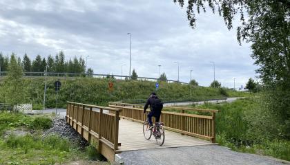 Vähäjärvenpuiston silta, jota ylittää pyöräilijä.
