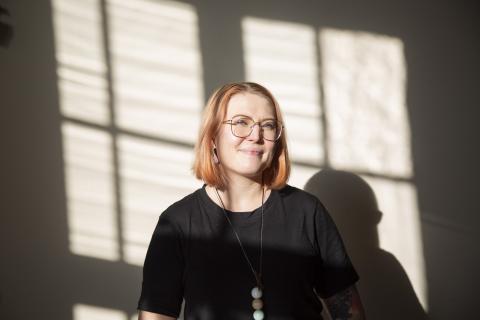 Naisen kasvokuva, jossa aurinko paistaa kasvoille ja takana näkyy varjo.