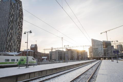 Aamuaurinkoinen kuva rautatieasemasta radoilta kuvattuna.