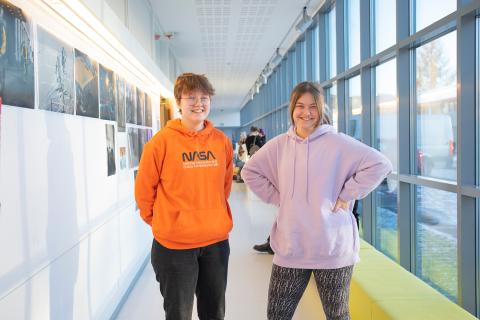 Kaksi nuorta seisoo lukion lasiseinäisellä käytävällä.