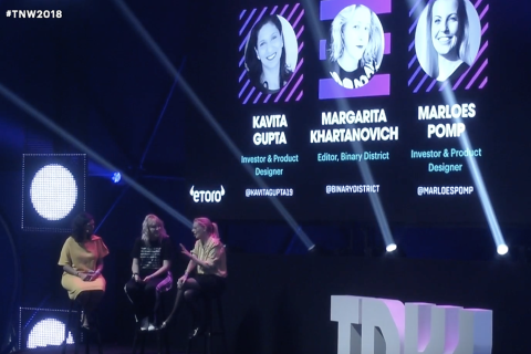 Margarita Khartanovich speaking in a panel discussion, with her name and photo seen at the background with other speakers