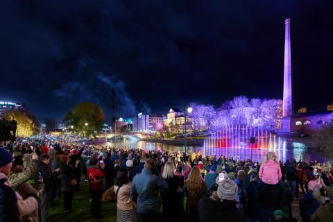 People gazing at the Dancing waters fountain show on a dark autumn evening.