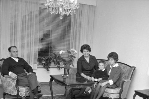 Väinö Linna perheensä kanssa kotonaan istumassa sohvalla ja katsoo kameraan.  