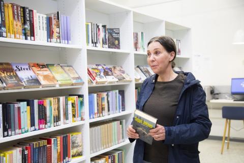 Kirsi Jänne on kirjastossa lainaamassa kaunokirjallisuutta.