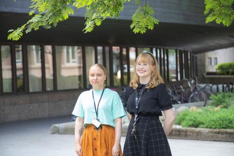 Kaksi kirjaston kesätyöntekijää seisovat puun alla Metso kirjastolla.