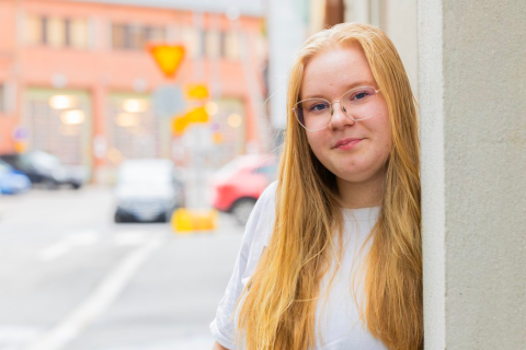 Venla Vuorinen stands on a street and looks at the camera.