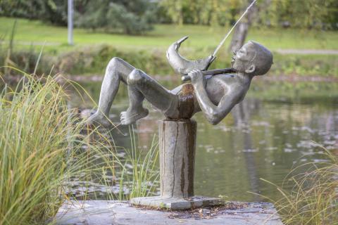 Pronssinen patsas, jossa kuvattuna poika ja kala.