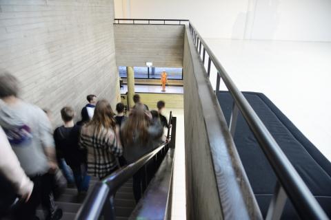Seitsemäsluokkalaiset kulkevat Sara Hildénin taidemuseon portaita alas kohti taustalla näkyvää näyttelytilaa.