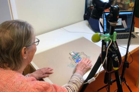 Iäkäs nainen tekee animaatiota piirroshahmoilla.