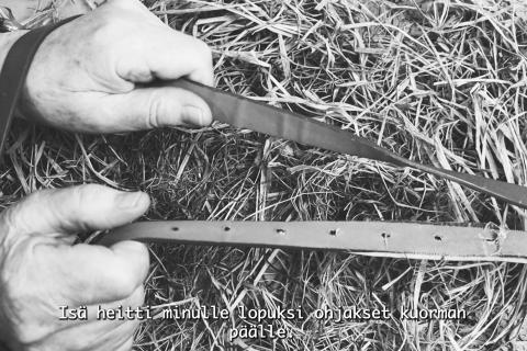 Kädet pitelevät nahkaremmejä kuten hevosen ohjaksia.