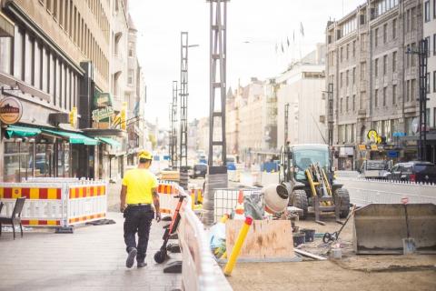Hämeenkadulla oleva rakennustyömaa. Työmies kävelee kuvan etualalla.