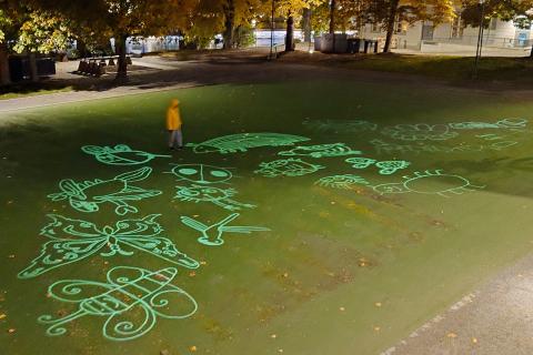 Maassa erilaisia ötököitä valoinstallaationa toteutettuna.