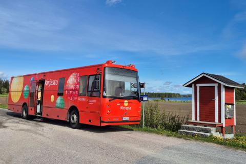 The mobile library Kustaa next to a field.