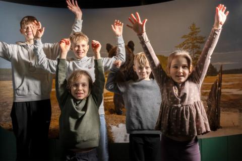 Children raise their hands at Vapriikki.